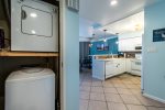 MP115 entrance, washer and dryer, tile floor, beach wall art, kitchen area